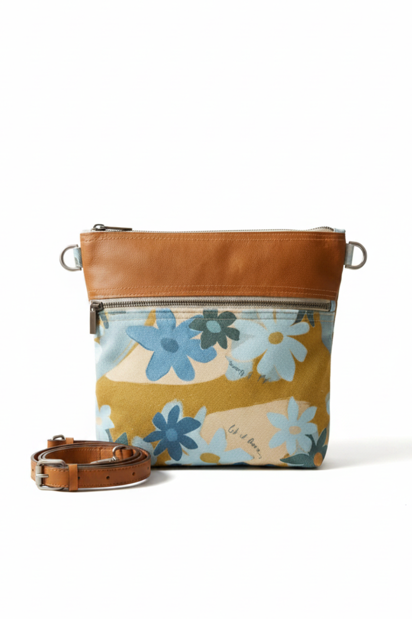 a canvas floral bag with a leather trim and crossbody strap